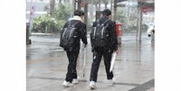 Students are seen walking without coats on as it snows in the city of Kagoshima on Jan. 24, 2023. The low temperature on this day was 2 degrees Celsius below zero. (Mainichi/Keisuke Muneoka)