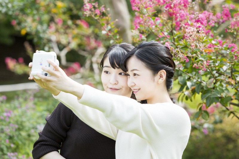 写真を撮影される秋篠宮ご夫妻の長女小室眞子さんと次女佳子さま＝東京都港区の赤坂御用地で2020年10月6日（宮内庁提供）