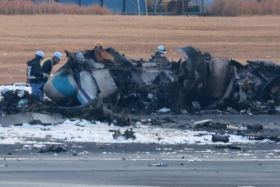 炎上した海保機を調べる関係者ら＝羽田空港で2024年1月3日午前7時29分、渡部直樹撮影