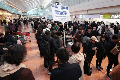 日本航空機と海上保安庁の航空機が衝突した事故の影響で欠航便が出る中、チェックインカウンターに並ぶ人たち＝羽田空港で2024年1月3日午前8時33分、渡部直樹撮影