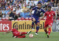Palestine's Musab Battat, right, and Ismail Alamour compete for the ball with Japan's Yuto Nagatomo, center, during the AFC Asia Cup soccer match between Japan and Palestine in Newcastle, Australia, on Jan. 12, 2014. (AP Photo/Rob Griffith, File)