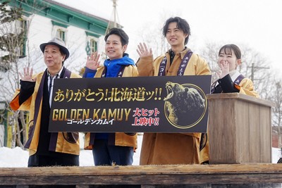映画「ゴールデンカムイ」のPRイベントでテレビカメラに手を振る（左から）久保茂昭監督、鈴木直道北海道知事、俳優の山﨑賢人さん、女優の山田杏奈さん＝札幌市厚別区の「北海道開拓の村」で2024年1月31日、貝塚太一撮影