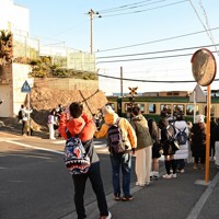 江ノ島電鉄鎌倉高校前駅近くの踏切で、ルールを守り歩道側で電車を撮影する外国人観光客ら＝神奈川県鎌倉市で2024年1月25日午後4時9分ごろ、橋本利昭撮影