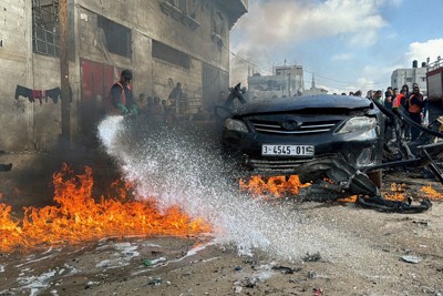 イスラエル軍の攻撃で炎上した車の消火活動を行う消防隊＝パレスチナ自治区ガザ地区南部ラファで2024年2月10 日、ロイター