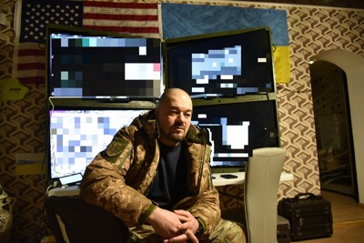多数のドローンから送られてくる映像の分析により、戦場の状況把握をしているウクライナ軍ドローン部隊所属のニューグティンさん（背後のモニター画面は加工しています）＝ウクライナ東部ドネツク州で2024年2月16日、鈴木一生撮影