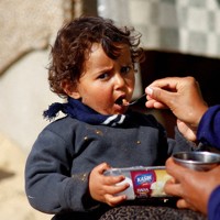 食事をする避難民の子供＝パレスチナ自治区ガザ地区南部ラファで2024年2月20日、ロイター