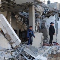 イスラエル軍の空爆を受けた住宅跡に立つ子どもたち＝パレスチナ自治区ガザ地区南部ラファで2024年2月21日、ロイター