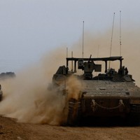 イスラエルとガザの境界付近を走るイスエル軍の兵員輸送車＝2月23日、ロイター