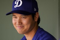 Los Angeles Dodgers designated hitter Shohei Ohtani smiles in the dugout before a spring training baseball game against the Texas Rangers, on Feb. 28, 2024, in Surprise, Ariz. (AP Photo/Lindsey Wasson)