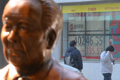取引時間中に4万円台になった日経平均株価を示す証券会社のモニター（奥）。手前は複合施設「KABUTO ONE」内にある渋沢栄一像＝東京都中央区で2024年3月4日、宮間俊樹撮影
