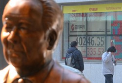 取引時間中に4万円台になった日経平均株価を示す証券会社のモニター（奥）。手前は複合施設「KABUTO ONE」内にある渋沢栄一像＝東京都中央区で2024年3月4日、宮間俊樹撮影