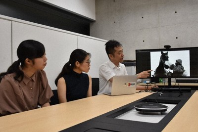 戦場（せんじょう）で働（はたら）かされた馬（うま）の写真（しゃしん）を見（み）ながら話（はな）し合（あ）う（左（ひだり）から）岡野（おかの）明莉（あかり）さん、冨田（とみた）萌衣（もえ）さん、渡邉（わたなべ）英徳（ひでのり）教授（きょうじゅ）＝東京都文京区（とうきょうとぶんきょうく）の東京（とうきょう）大学（だいがく）で