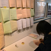 被災体験を記入する女性＝富山市科学博物館で2024年2月29日、青山郁子撮影