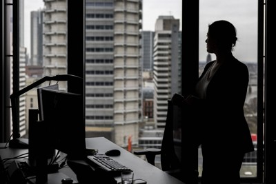 オフィスにたたずむ女性＝DPA・ロイター