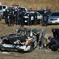 行方不明者の一斉捜索を前に、殉職した2人が乗っていたパトカーに献花する警察官ら＝福島県富岡町で2014年3月11日、小出洋平撮影