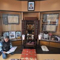 佐藤雄太さんへ宛てられた手紙を読む、父の安博さん。パトカーの横に設置されたポストには、約1000通もの手紙が寄せられたという＝福島市で2024年2月2日、手塚耕一郎撮影