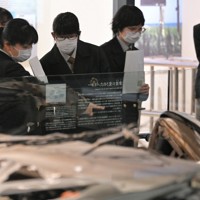 避難誘導中、津波に襲われて殉職した2人の警察官が乗っていたパトカーを見学する、いわき市から訪れた高校生＝福島県富岡町のとみおかアーカイブミュージアムで2024年2月1日、手塚耕一郎撮影