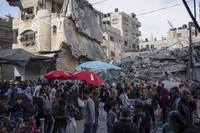 イスラエル軍の空爆で破壊された住宅付近で買い物をする市民＝パレスチナ自治区ガザ地区南部ラファで2024年3月14日、AP