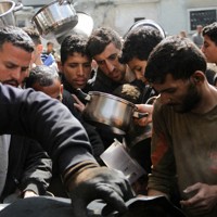 イスラエルとハマスの戦闘が続く中、食料の無料配給に集まる市民＝パレスチナ自治区ガザ地区北部ジャバリアで3月19日、ロイター