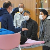 能登半島地震の避難所を訪問され、被災した新谷満さんに声をかける天皇、皇后両陛下。奥は坂口茂輪島市長＝石川県輪島市のふれあい健康センターで2024年3月22日午後1時54分、手塚耕一郎撮影