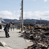 大規模火災が発生した「輪島朝市」を訪問され、被災現場で黙礼する天皇、皇后両陛下＝石川県輪島市で2024年3月22日午後1時36分（代表撮影）