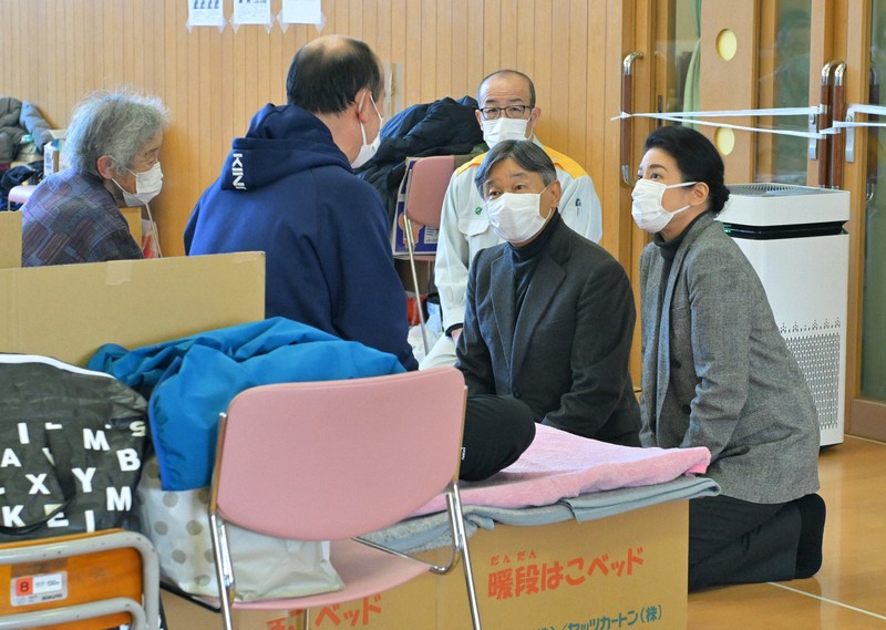 能登半島地震の避難所を訪問され、被災した新谷満さん（左手前）、千恵子さん（左端）親子に声をかける天皇、皇后両陛下。奥は坂口茂輪島市長＝石川県輪島市のふれあい健康センターで2024年3月22日午後1時55分、手塚耕一郎撮影