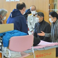 能登半島地震の避難所を訪問され、被災した新谷満さん（左手前）、千恵子さん（左端）親子に声をかける天皇、皇后両陛下。奥は坂口茂輪島市長＝石川県輪島市のふれあい健康センターで2024年3月22日午後1時55分、手塚耕一郎撮影