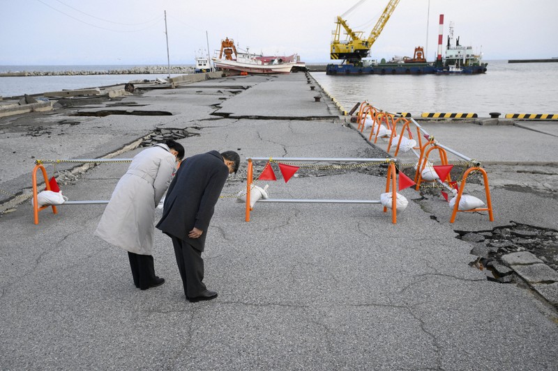 能登半島地震で被害を受けた石川県珠洲市の飯田港を訪れ、黙礼される天皇、皇后両陛下＝2024年3月22日午後5時44分（代表撮影）