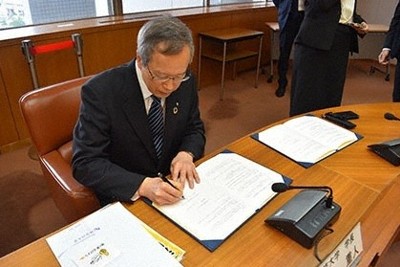 協定書にサインする佐々木学長