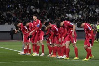 North Korea's players greet their supporters at the end of the FIFA World Cup 2026 and AFC Asian Cup 2027 preliminary joint qualification round 2 match between Japan and North Korea at the National Stadium in Tokyo, on March 21, 2024. (AP Photo/Eugene Hoshiko)
