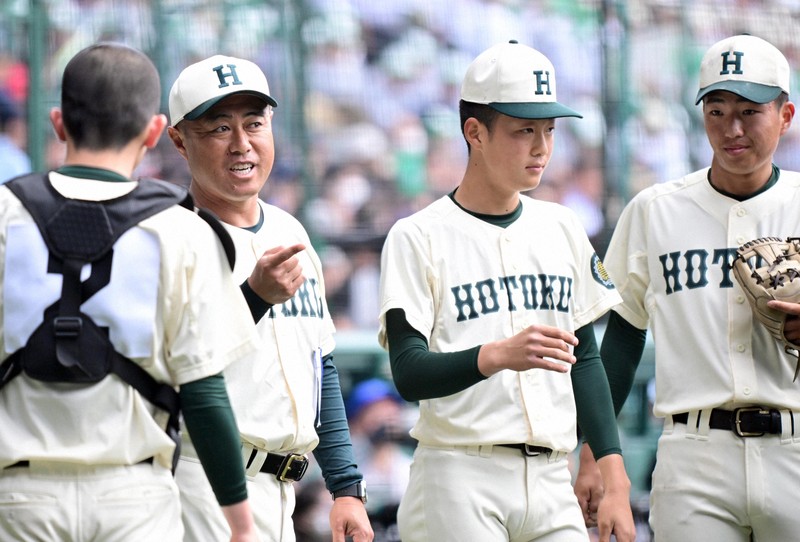 【報徳学園－健大高崎】ベンチ前で選手たちに声を掛ける報徳学園の大角健二監督（左から2人目）＝阪神甲子園球場で2024年3月31日、北山夏帆撮影