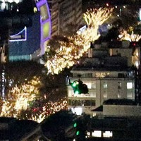 東京・六本木にある米軍ヘリポートへの着陸に向けて、イルミネーションの輝く表参道周辺を通過した米空軍ヘリ「UH1」（手前）＝2022年12月6日午後7時48分ごろ、都心の200メートル級のビルより取材班が撮影した動画から