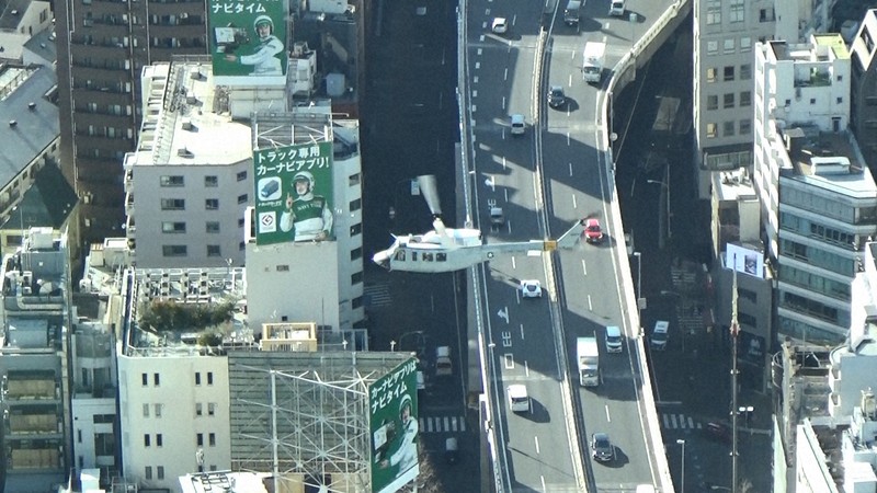 東京都港区西麻布の市街地上空を通過する米空軍ヘリ「UH1」＝2023年1月26日午後2時23分ごろ、都心の200メートル級のビルより取材班が撮影した動画から