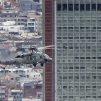 東京都世田谷区太子堂の「キャロットタワー」（高さ124メートル）手前を通過する米海軍ヘリ「シーホーク」＝都内で2020年12月14日午後1時25分ごろ、大場弘行撮影（写真は動画から）