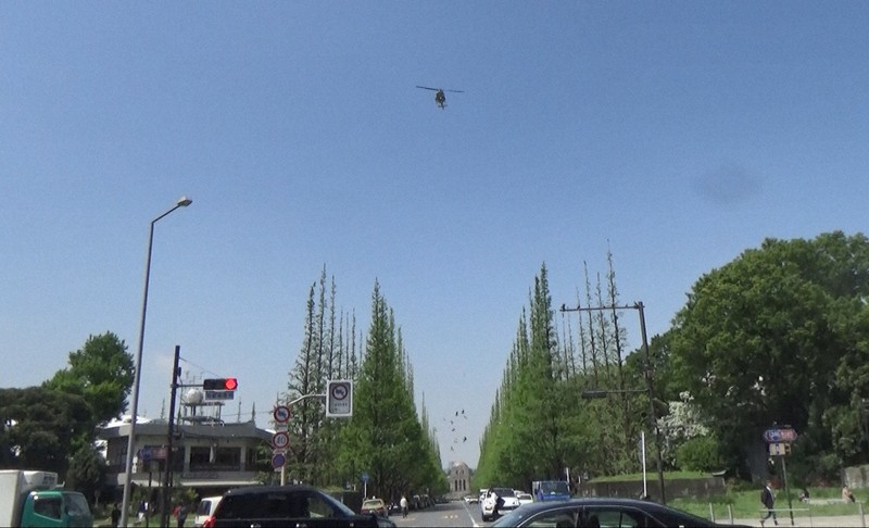 東京・六本木のヘリポートに向かうため、神宮外苑のイチョウ並木に沿うように飛ぶ米空軍ヘリ「UH1」＝2023年4月20日午後0時53分ごろ、港区北青山の神宮外苑付近で取材班撮影