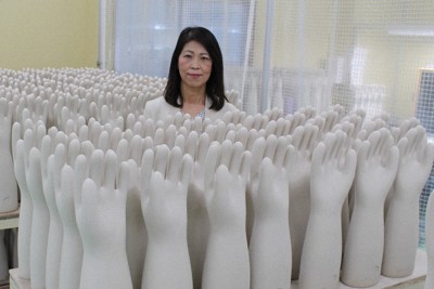 ずらりと並ぶセラミックの手型に囲まれる鈴木規子社長。「商品は最強の営業マン」と品質にこだわる＝三重県四日市市で2024年3月7日、松本宣良撮影