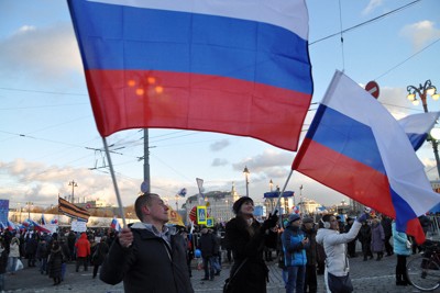 集会でロシア国旗を振るプーチン政権支持者たち＝モスクワで2016年3月、真野森作撮影