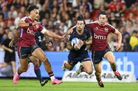 Connor Garden-Bachop, center, of the Highlanders is tackled by Jordan Petaia, left, and Jock Campbell of the Queensland Reds during their Super Rugby Pacific game at Suncorp Stadium in Brisbane, Australia, on April 19, 2024. (Darren England/AAP Image via AP)