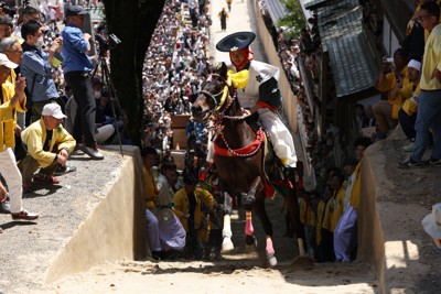 多度大社の上げ馬神事で、土壁が撤去されて緩やかになった坂を駆け上がる馬と騎手＝三重県桑名市の多度大社で2024年5月4日午後1時2分、兵藤公治撮影