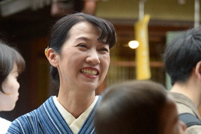 忙しい業務の中を縫い、おかげ横丁やおはらい町を歩き問題点や改善点を探る「伊勢福」社長の濵田朋恵さん。観光で訪れたかつての従業員と会うと気さくに声を掛けた＝三重県伊勢市宇治中之切町で2024年5月12日、大竹禎之撮影
