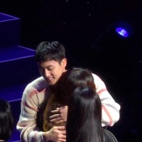 韓国ソウルのイベントでファンとハグするBTSのジンさん＝13日、ロイター（SNS上の動画から）