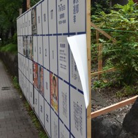 画びょうで留められたクリアファイル入りの候補者ポスター（右端）。風にひらひらと揺れていた＝東京都新宿区で2024年6月20日午後4時7分、田中綾乃撮影