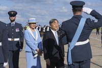 Emperor Naruhito is saluted by a member of the honor guard as he and Empress Masako arrive at Stansted Airport, England, on June 22, 2024, ahead of a state visit. (AP)