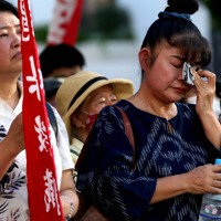 米兵による性的暴行事件に対する抗議集会で、登壇者の話を聞き涙をぬぐう参加者たち＝那覇市で2024年7月4日午後5時39分、喜屋武真之介撮影