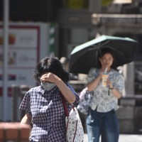 照りつける日差しの下、手をかざしたり、日傘を差したりしながら歩く人たち＝静岡市駿河区のJR静岡駅南口で2024年7月4日午後2時37分、丹野恒一撮影