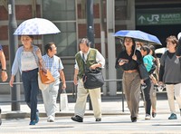 People hold up parasols for shade amid the harsh heat in Tokyo's Chiyoda Ward on July 5, 2024. (Mainichi/Mimi Niimiya)