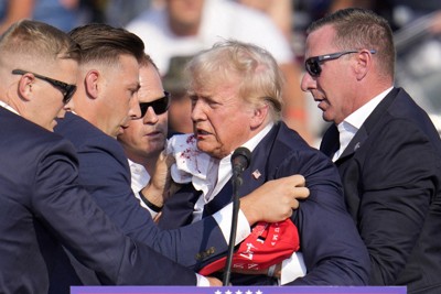 演説中に銃撃され、壇上から降りるのに助けられるトランプ前米大統領＝米東部ペンシルベニア州で7月13日、AP