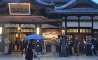 People wait in line in front of Dogo Onsen Honkan in the city of Matsuyama, Ehime Prefecture, on July 11, 2024. Around 50 people had been waiting in the rain for the 6 a.m. opening of the facility. (Mainichi/Hiroyuki Yamanaka)