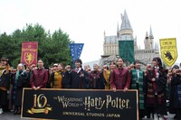 With Hogwarts Castle in the background, actor Seishiro Kato, center, and fans toast with "butterbeer" to celebrate the 10th anniversary of the opening of the Harry Potter area at Universal Studios Japan in Osaka's Konohana Ward on July 15, 2024. (Mainichi/Makiko Nagao)