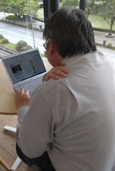 This image shows an office worker suffering from stiff shoulders in Tokyo's Chiyoda Ward. (Mainichi)
